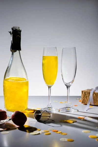 Close View Glassware Yellow Champagne Wrapped Gift Grey Backdrop — Free Stock Photo