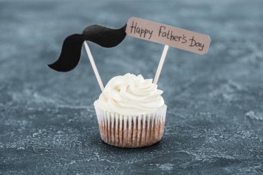 delicious cupcake with mustache sign and Happy fathers day inscription on concrete surface clipart