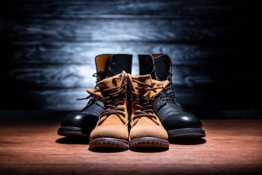 close-up shot of vintage father and son leather boots on wooden surface, Happy fathers day concept clipart