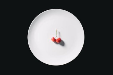 taze olgun tatlı Sarı kiraz üstten görünüm yuvarlak beyaz tabakta üzerine siyah izole