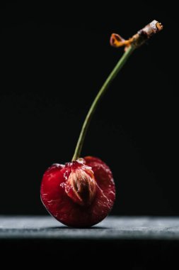close-up view of half of fresh ripe cherry on black clipart