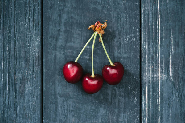 top view of tasty healthy red cherries on rustic wooden surface
