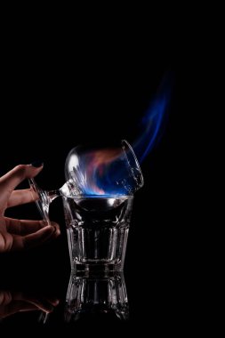 kısmi görünümünü sambuca alkol içki siyah arka plan üzerine yanma ile cam tutan kadın
