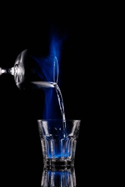 siyah arka plan üzerine dökerek yanan sambuca alkol içki cam sürecine görünümünü kapat