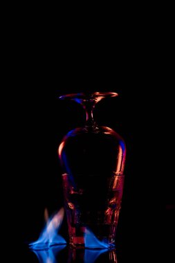 close up view of glasses and burning sanbuca alcohol drink around on black background clipart