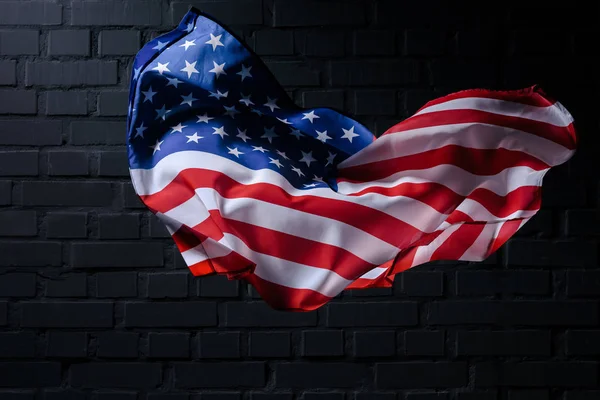 Dinamik Sallayarak Amerika Birleşik Devletleri Bayrağı Önünde Siyah Tuğla Duvar — Stok fotoğraf