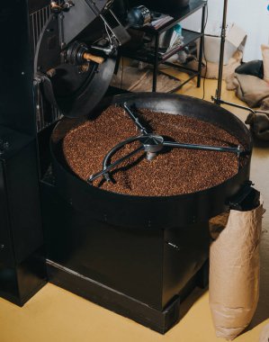 Industrial coffee roaster with large paper bags filled with coffee beans clipart
