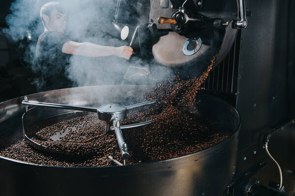 Professional male roaster loading machine with coffee beans