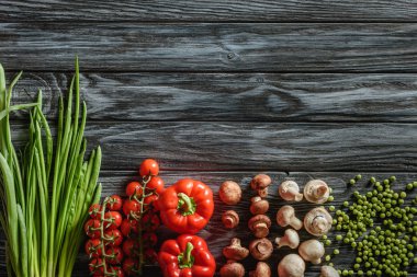 top view of various raw vegetables on wooden tabletop clipart