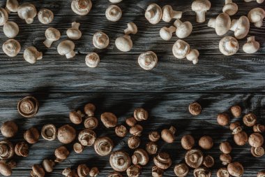 ahşap yüzey üzerinde ayrılmış beyaz ve kahverengi champignon mantar üstten görünüm