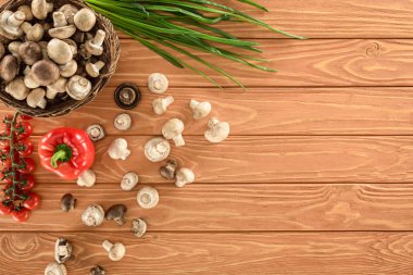 ahşap masa üzerinde champignon mantar ve çeşitli sebzelerin üstten görünüm