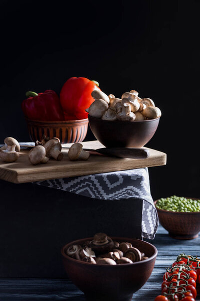 champignon mushrooms and different vegetables on table on black