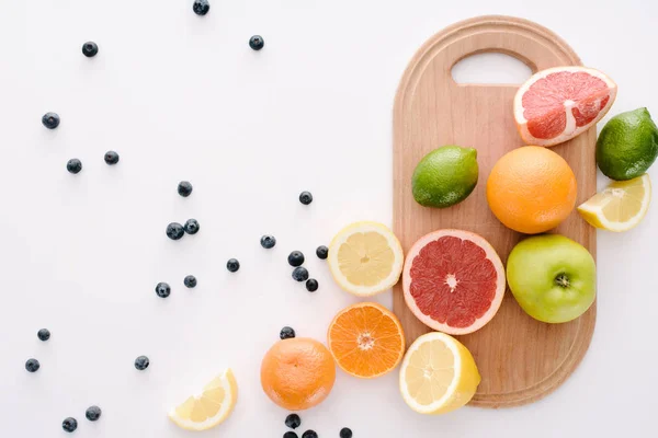 蓝莓和白色表面木制切割板柑橘类水果的顶部视图 — 免费的图库照片