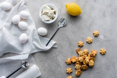 düz lay ile düzenlenmiş limon, ekşi krema, çiğ tavuk yumurtası ve gri yüzeyi pasta kurabiye