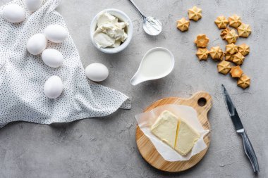 düz lay kesilmiş tereyağı, kurabiye ve pasta gri yüzeyinde yapmak için çiğ tavuk yumurta malzemeler ile