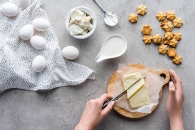 atış için gri masa üzerinde ev yapımı pasta kesme tahtası üzerine kadın kesme tereyağı kırpılmış