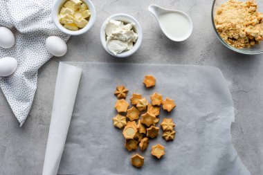 düz lay çerezleri, çiğ tavuk yumurta, tereyağı ve üzerinde gri masa üstü düzenlenmiş pasta yapmak için ekşi krema ile