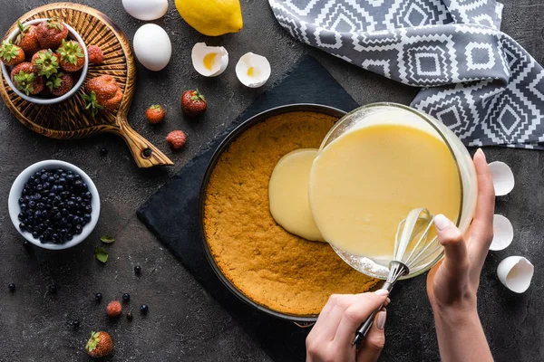 Krem pasta hamuru koyu gri yüzeyi görücü usulü malzemelerle dökme kadının kısmi görünümü