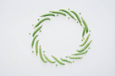 top view of round frame made of fresh green peas isolated on white background clipart