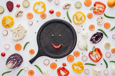 gülen yüz yeşil bezelye ve kırmızı biber üstten görünüm üzerinde beyaz izole yuvarlak ahşap tahta üzerinde