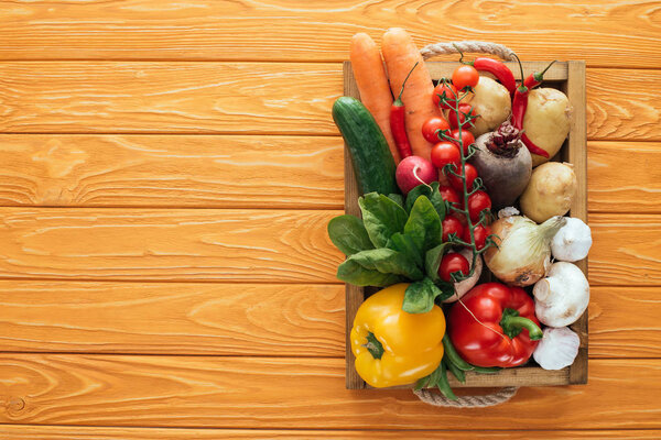 top view of fresh raw healthy vegetables in box on wooden table top