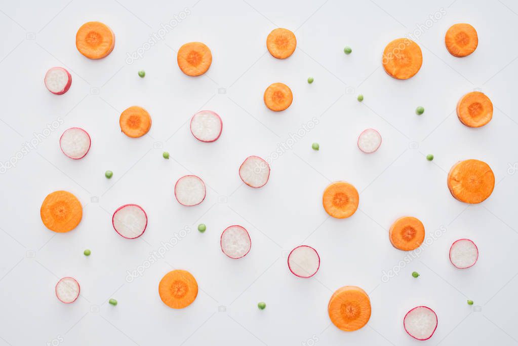 top view of fresh sliced carrot, radish and green peas isolated on white background
