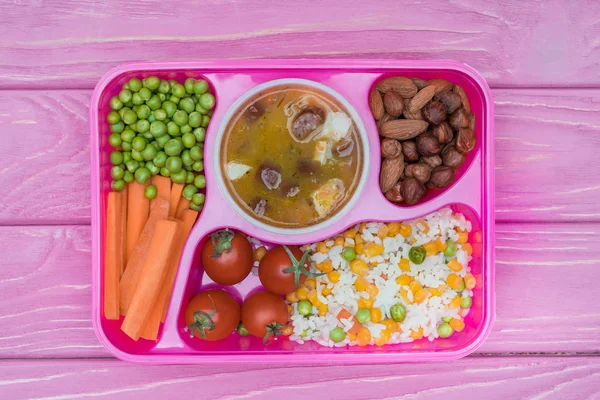 顶部视图的托盘与儿童午餐在粉红色的桌子上学校 — 图库照片