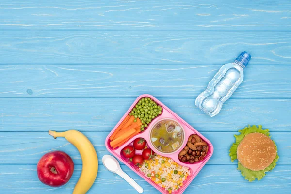 Top view of tray with kids lunch for school, bottle of water and fruits on blue wooden surface — Stock Image Top View Tray Kids Lunch School Bottle Water Fruits Blue Royalty Free Stock Images
