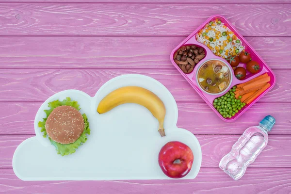 Top view of tray with kids lunch for school, burger and fruits on pink table — Stock Image Top View Tray Kids Lunch School Burger Fruits Pink Table Stock Photo