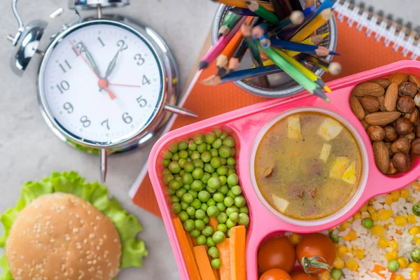 Top view of tray with kids lunch for school, alarm clock and colored pencils on table — Stock Image Top View Tray Kids Lunch School Alarm Clock Colored Pencils Stock Picture