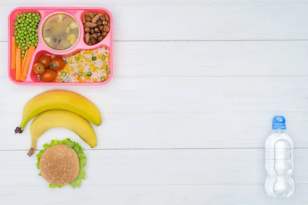 Top view of tray with kids lunch for school, bananas and plastic bottle of water on white table — Stock Image Top View Tray Kids Lunch School Bananas Plastic Bottle Water Royalty Free Stock Images