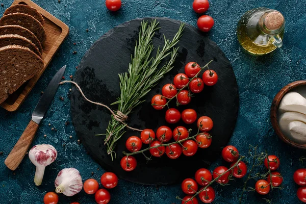 Red tomatoes with herbs and bread on dark blue table — Stock Image Red Tomatoes Herbs Bread Dark Blue Table Stock Photo