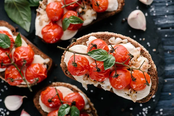 Läckra Smörgåsar Med Mozzarella Och Bakade Tomater Mörka Träbord — Stockfoto