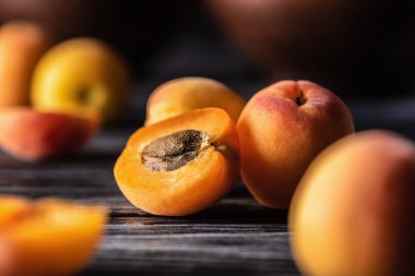 selective focus of ripe apricots on wooden table clipart