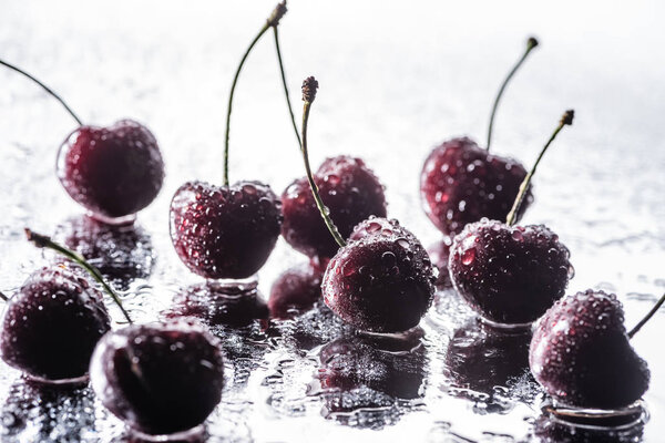 red ripe cherries with water drops on wet surface 