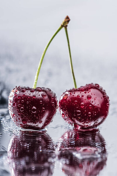 close up view of red ripe cherries with water drops on wet surface 