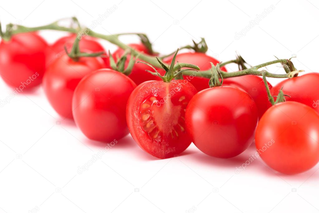 close up view of ripe cherry tomatoes on twig isolated on white