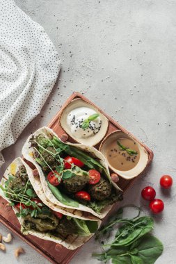 falafel ekmeği, domates ve Ayçiçeği tohumları germinated en iyi görünümü gri yüzeyi ahşap tahta yılları arasında görev yapmıştır