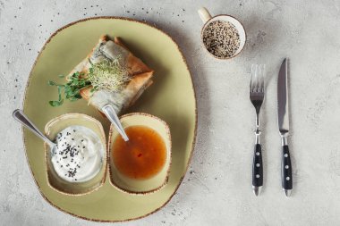 yonca ve gri masa üstü tabakta servis Ayçiçeği tohumları germinated düz lay samosas ıspanak ve paneer doldurulmuş phyllo hamur içinde ile süslenmiş