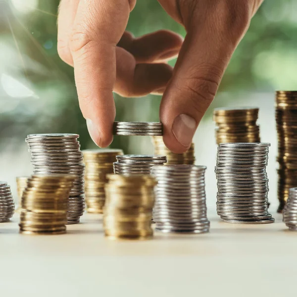 Bijgesneden Weergave Van Persoon Stapelen Munten Tafel Wazig Groene Achtergrond — Stockfoto