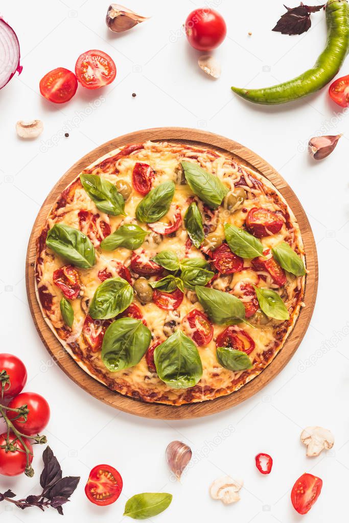 top view of delicious italian pizza on wooden board and various ingredients on white