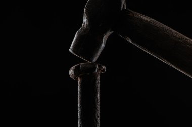  close up view of vintage hammer and nail isolated on black