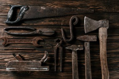 flat lay with assortment of vintage rusty carpentry tools on wooden surface clipart