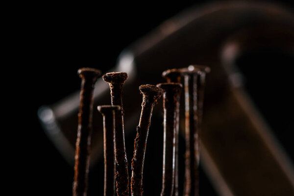  selective focus of retro rusty nails and hammer isolated on black