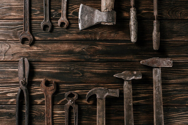 flat lay with assortment of vintage rusty carpentry tools on wooden surface