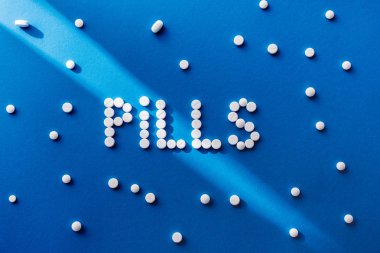 tarafından mavi zemin üzerine beyaz tablet hap yazı yükseltilmiş görünümü 