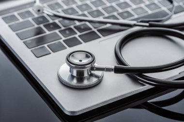 seçici odak stetoskop ve cam yüzey üstünde laptop 