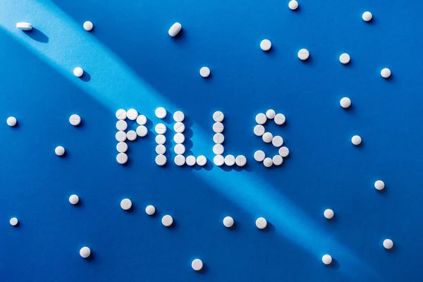 Elevated View Lettering Pills White Tablets Blue Background — Free Stock Photo