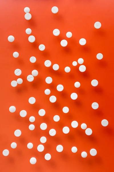 Вид Сверху Груду Белых Таблеток Красном Фоне — Бесплатное стоковое фото