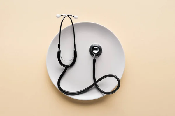 Top View Plate Stethoscope Beige Background — Stock Photo, Image